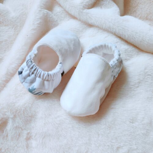 chaussons blancs sur couverture blanche