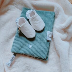 chaussons bébé posés sur un carnet de santé bleu